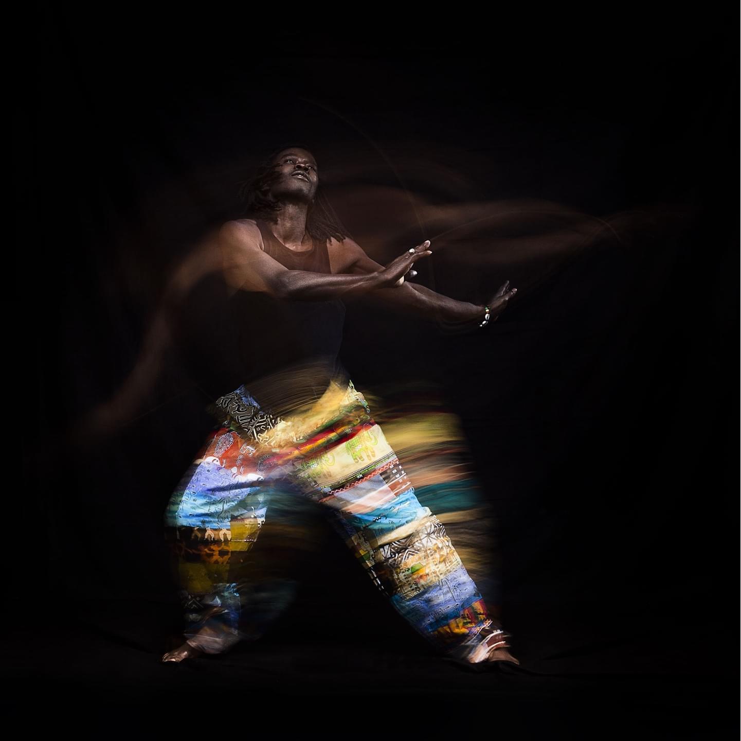 Senegalese dancer moving slowly like he has fallen into a trance.